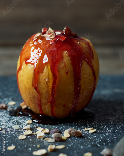 baked apple with caramellized sugar, strawberry topping, cereal and racin photo