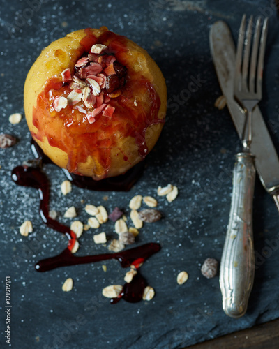 baked apple with caramellized sugar, strawberry topping, cereal and racin photo