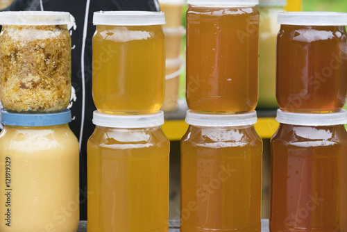 Stack of glass jars with yellow honey