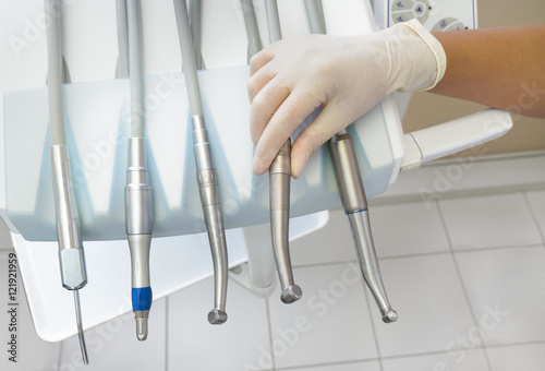 Dentist holding a dental instrument on the table