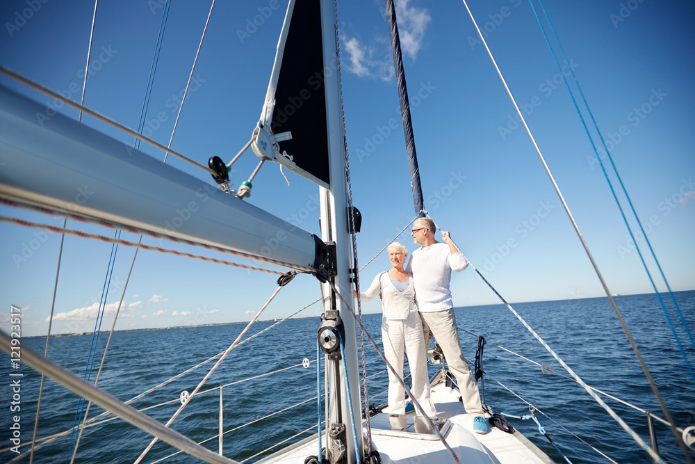 Fototapeta premium senior couple hugging on sail boat or yacht in sea
