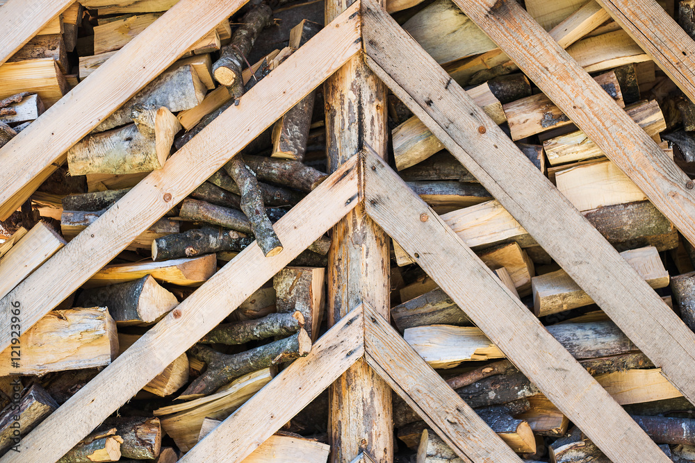 Many dry chopped firewood in storage ready for use in cold winter season. Brown color wood background. Horizontal color image. Many dry chopped firewood in storage ready for use in cold winter season. Brown color wood background. Horizontal color image.
