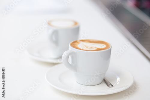 Two cups of cappuccino on counter in cafe