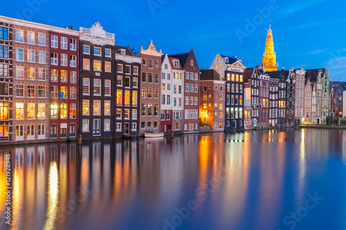 Amsterdam canal with Beautiful typical Dutch dancing houses and Oude Kerk church during twilight blue hour, Holland, Netherlands