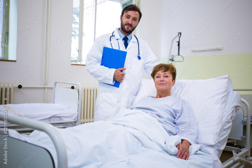 Smiling doctor and patient looking at camera in hospital Smiling doctor and patient looking at camera in hospital