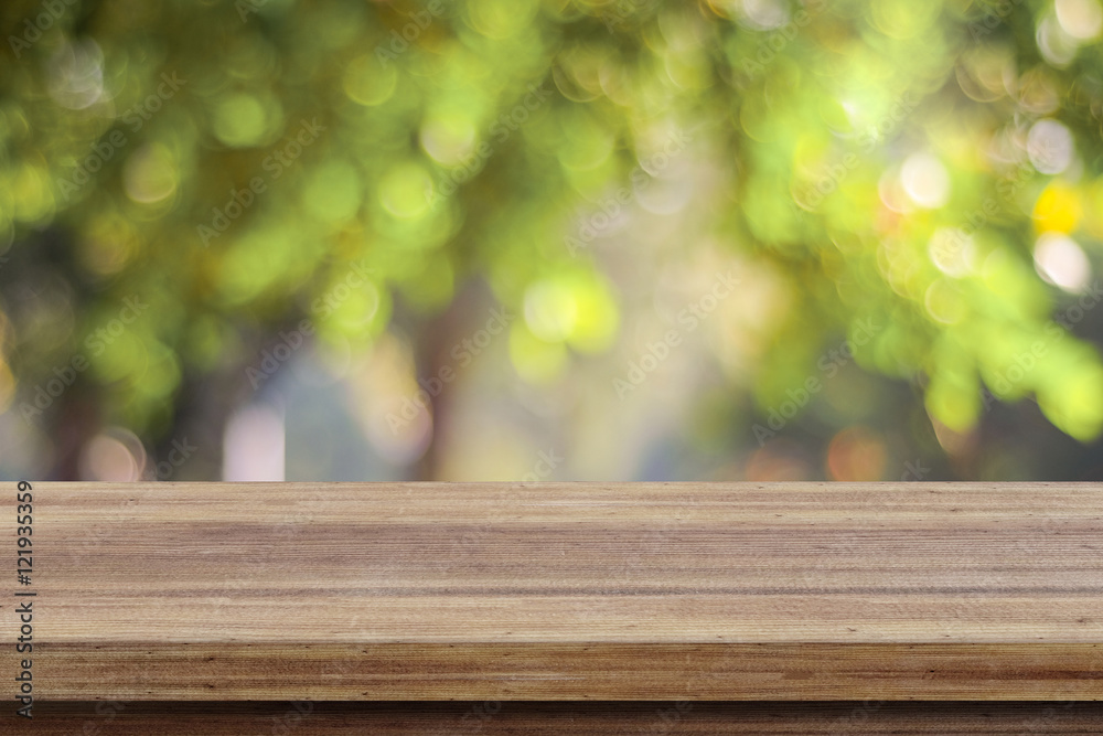 Empty wooden table over blurred tree with bokeh background Empty wooden table over blurred tree with bokeh background