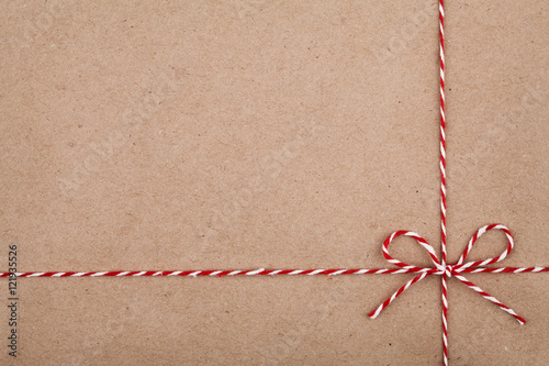 Christmas string or twine tied in a bow on kraft paper backdrop