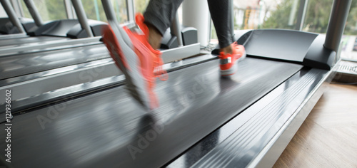 Foto Female foot running on treadmill - motion blur