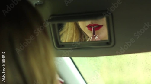 in the car putting on lipstick