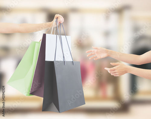 Borse dello shopping in mano con sfondo negozio
