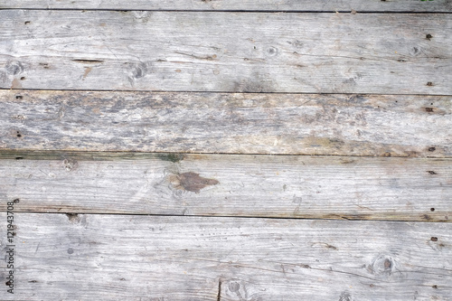 wooden background from old grey textured boards with little gap between it/different scale/hats of nails