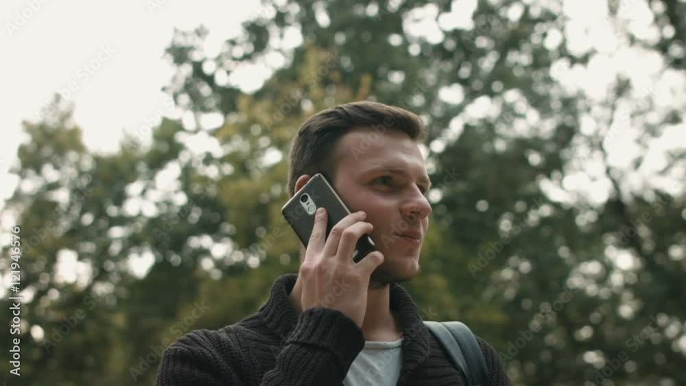 Handsome young business man talking on smartphone and walking away smiling happy wearing suit jacket outdoors. Handsome young business man talking on smartphone and walking away smiling happy wearing suit jacket outdoors.