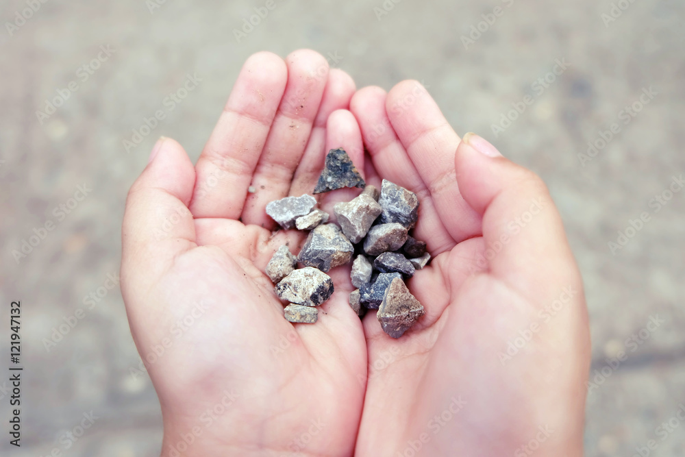 little girl hands holding small stones