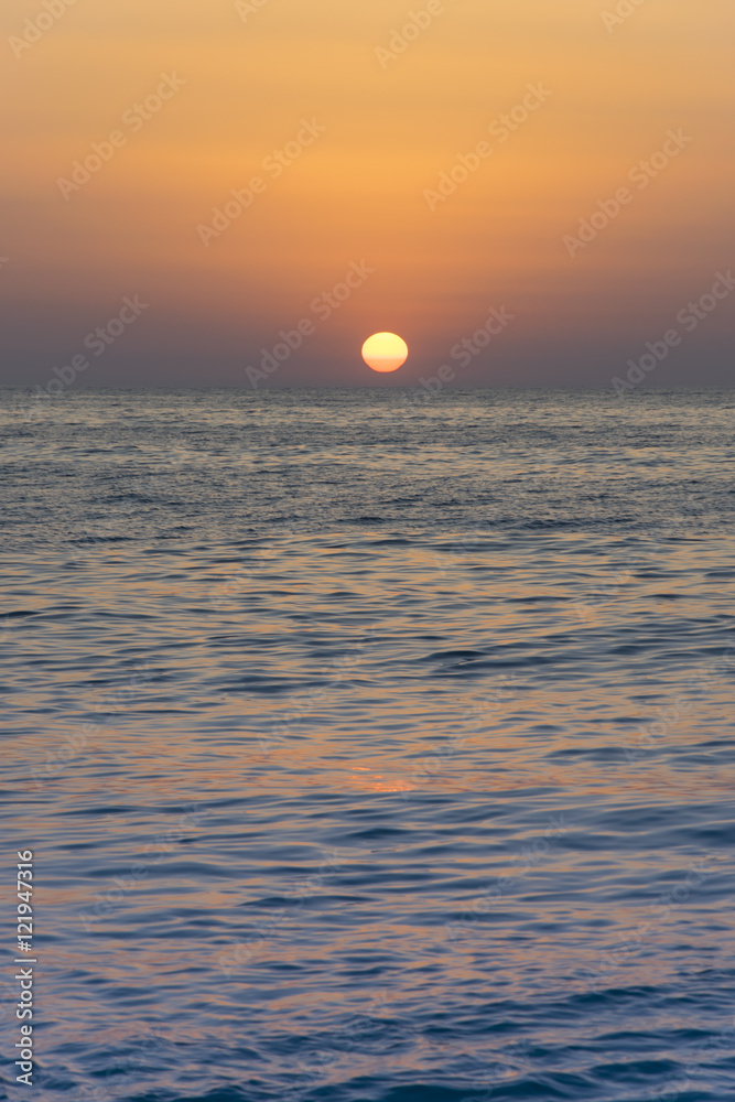 Orange yellow Sun sunsets over blue clear sky on the open sea 2