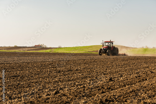 Farmer in tractor preparing land with seedbed cultivator