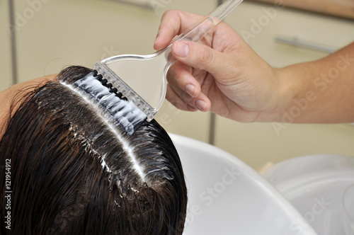 Hair coloring in salon. Stylist coloring hair in salon.