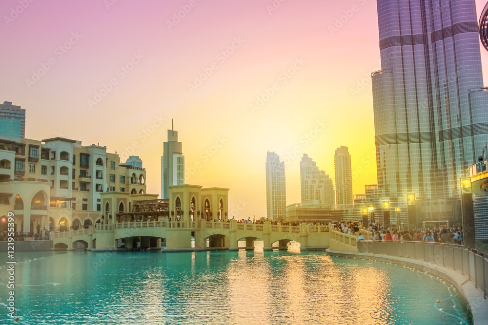 Fototapeta premium Scenic view of Burj Khalifa Lake, a pool where they dance the Dubai Fountain. On background, the Souk Al Bahar and Burj Khalifa at dusk in Dubai Downtown District, United Arab Emirates.