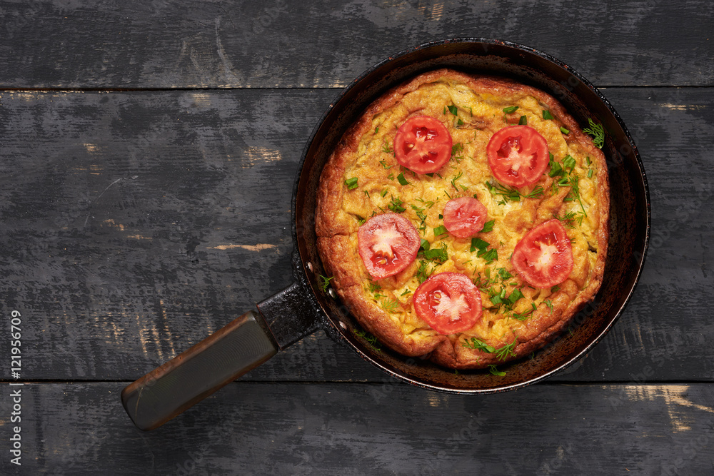 fried eggs in a pan with tomato on a table fried eggs in a pan with tomato on a table