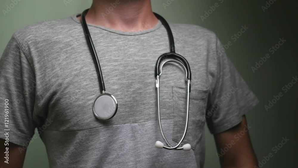 Student doctor putting a stethoscope around his neck. Stock Video Adobe Stock