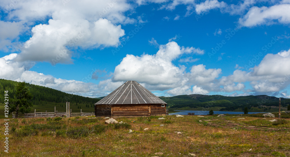 Traditional Altai dwelling on a background of lake and mountains. The Altai Republic. 