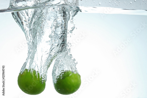 Two limes dropping in water