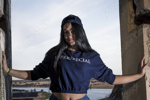 Chica morena con visera en la montaña. Chica súper especial. Chica joven posando con visera. Sesión con modelo en el castillo. photo