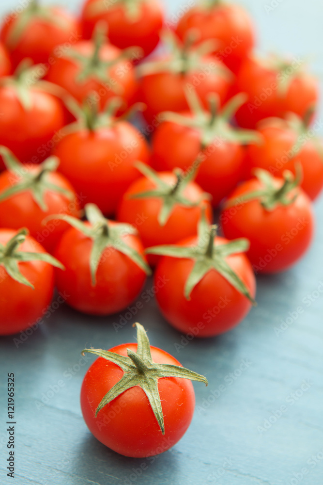 Small cherry tomatoes on a blue wooden Small cherry tomatoes on a blue wooden