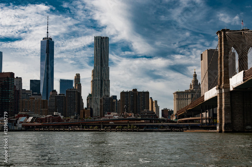 One World Trade Center building and the Brooklyn Bridge from the East River in New York City.