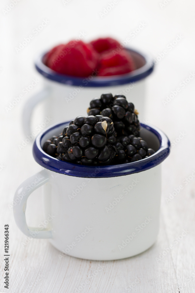 blackberries in white cup on blue wooden background blackberries in white cup on blue wooden background