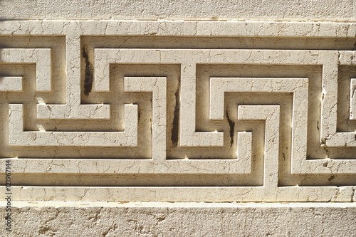 antique meander pattern on the stone wall 