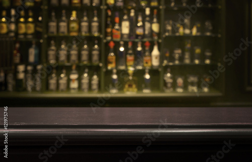Empty wood counter  bar  table with  blur  bottle background.