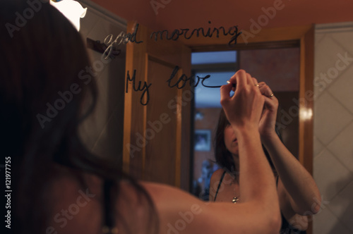 Lipstick inscription good morning mirror and the reflection of a