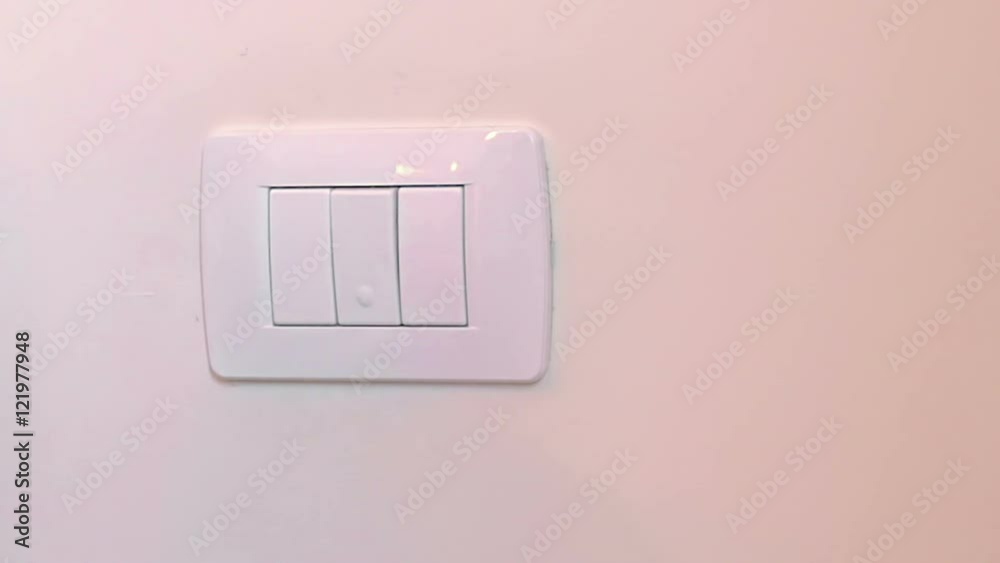 adorable little boy child turning on the white light-switch with his finger of little hand, new generation concept, close-up view