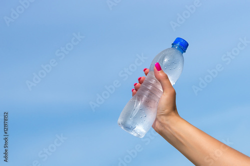 Woman hand holding water bottle outdoors