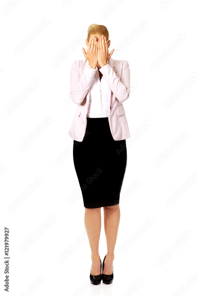 Troubled business woman covering her face with hands Troubled business woman covering her face with hands