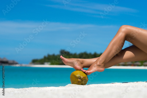 Beautiful female legs in the tropical beach conceptual image of