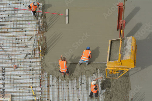 Construction builders applying and leveling cement in building s