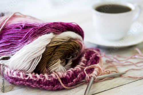 Skeins of wool and knitting needles on wooden background