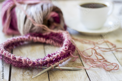Skeins of wool and knitting needles on wooden background