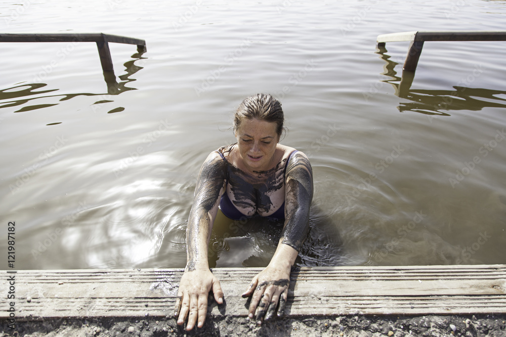 Woman giving himself a mud bath Stock Photo | Adobe Stock