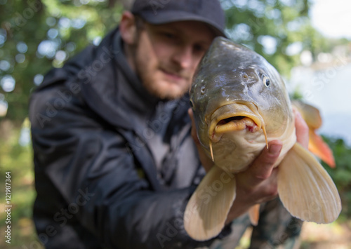 Happy angler with carp fishing trophy. 