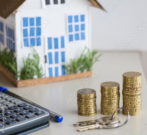Mortgage concept focused on the coins and keys real estate property with loan money bank concept.