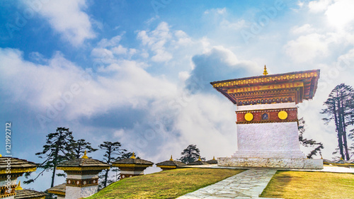 Dochula pass 108 chortens (Asian stupas) is the memorial in honour of the Bhutanese soldiers in the Timpu city with the grass landscape and cloudy sky background, Bhutan photo