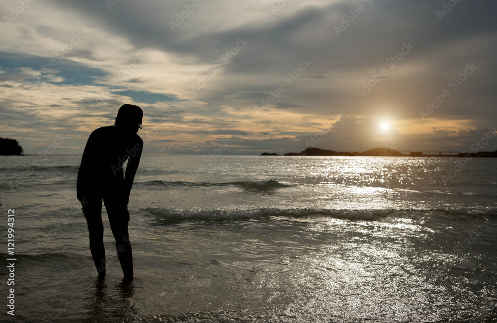 Young woman in summer dress standing on a rock and looking to a