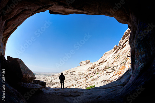 Man silhouette in front of a cave entrance