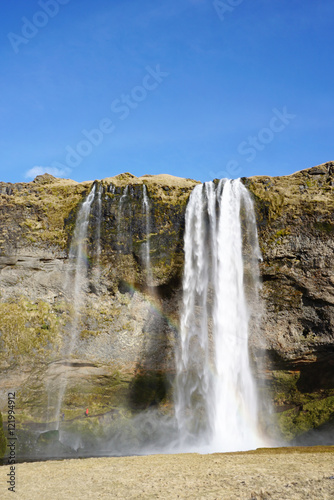 Beautiful Seljalandsfoss waterfall with river and meadow