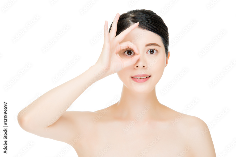 Close up young smiling woman with finger gesture on eyes Close up young smiling woman with finger gesture on eyes