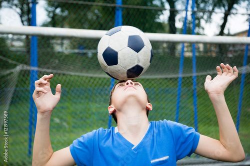 Boy juggling a soccer ball