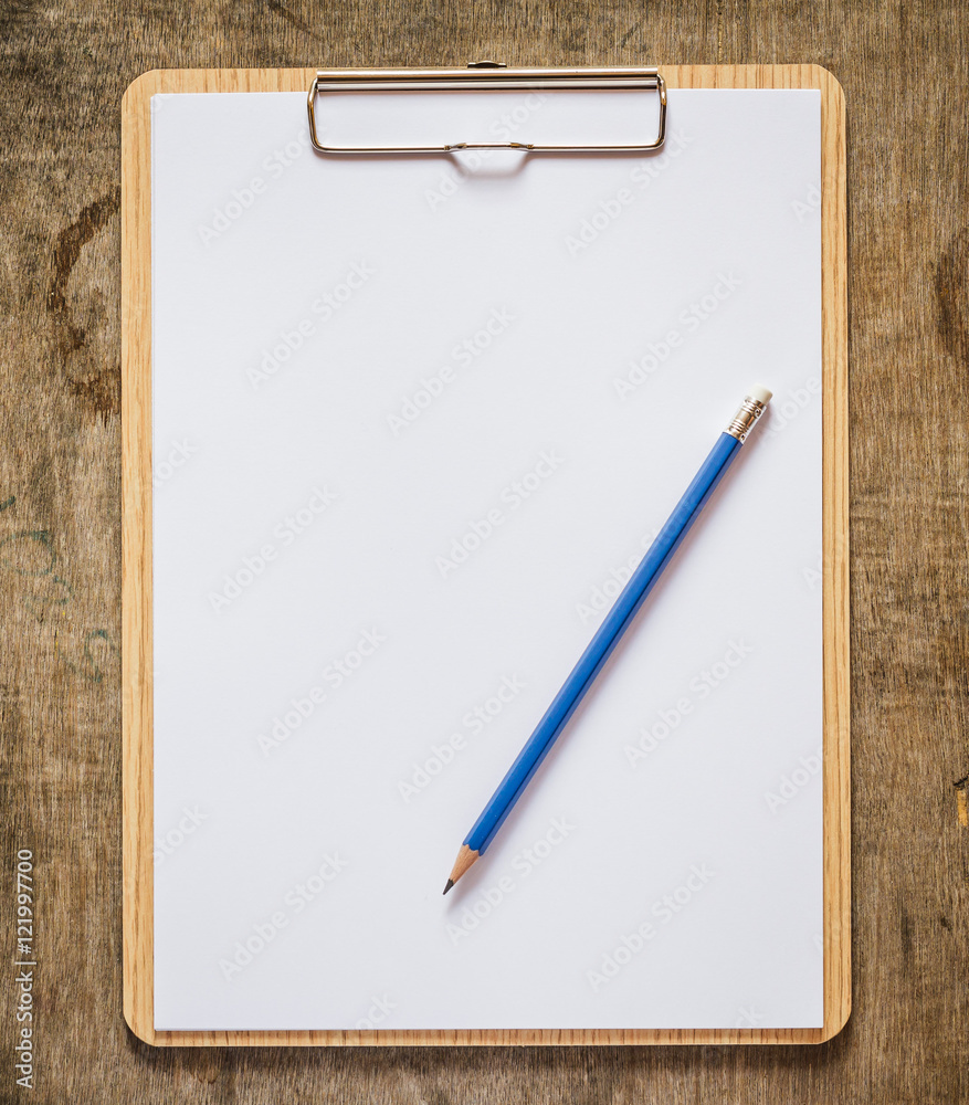 Clipboard with pencil on wooden table Clipboard with pencil on wooden table