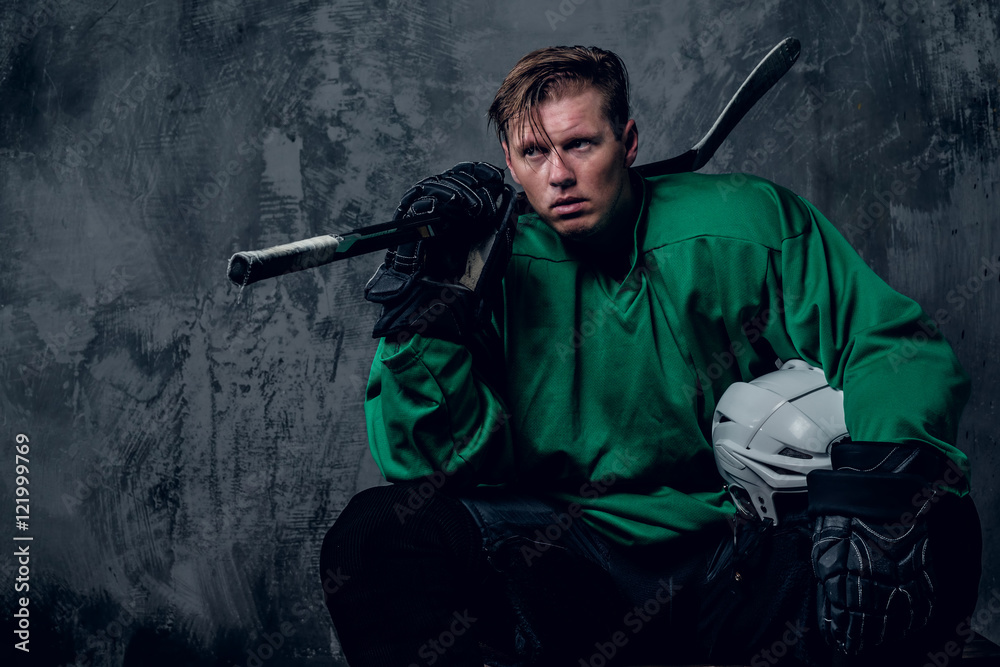 Fototapeta premium Tired hockey player relaxing on grey background.